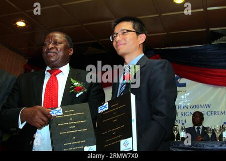 Noar Gwariro (L), CEO der Zimbabwe Power Company (ZPC), und Sinohydro-Vertreter in Simbabwe, Wu Yifeng, schütteln die Hände bei der Unterzeichnungszeremonie des Erweiterungsprojekts in Harare, Simbabwe, 10. Oktober 2014. Der ZPC und Chinas Sinohydro unterzeichneten am Freitag einen Vertrag über den Ausbau des Kraftwerks Hwange um 600 Megawatt zu Kosten von 1,17 Milliarden US-Dollar. SIMBABWE-SINOHYDRO-POWER-PROJEKT WangxYue PUBLICATIONxNOTxINxCHN Noar l CEO der Simbabwes Power Company und Sinohydro S-Vertreter in Simbabwe Wu Yifeng Shake Hands BEI der Unterzeichnungszeremonie des Erweiterungsprojekts in Harare Stockfoto