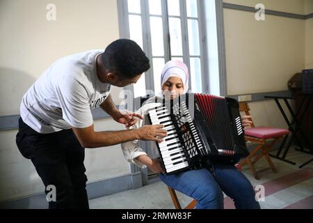 Kairo, Ägypten. 27. August 2023. Eine Dozentin unterrichtet ein Mädchen beim Musikunterricht im House of Art and Culture in Kairo, Ägypten, am 27. August 2023, wie man Akkordeon spielt. ZU GEHEN MIT "Feature: Non-Profit-Musikschule in Kairo bietet lebensverändernde Möglichkeiten für benachteiligte Jugendliche" Credit: Ahmed Gomaa/Xinhua/Alamy Live News Stockfoto