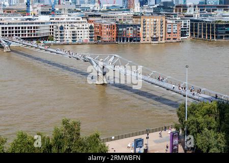 Fußgänger, die über die Millennium Bridge über die Themse in Central London, Großbritannien, laufen Stockfoto