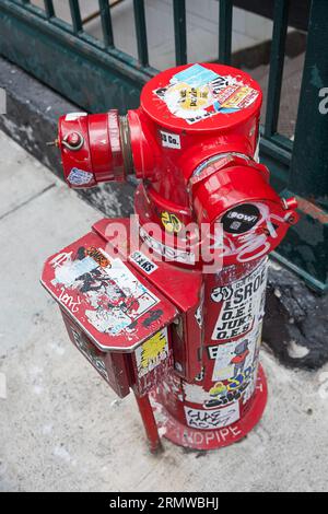 STREET ART. Collage von Graffiti und Aufklebern auf einem Hydranten in der Nähe der Grand Central Station an der East 42nd Street in Manhattan. Stockfoto