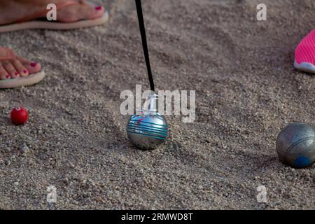 Petanque-Spiel. Sie können die Stahlkugeln in verschiedenen Farben und den Magneten sehen, mit dem sie gesammelt werden. Stockfoto