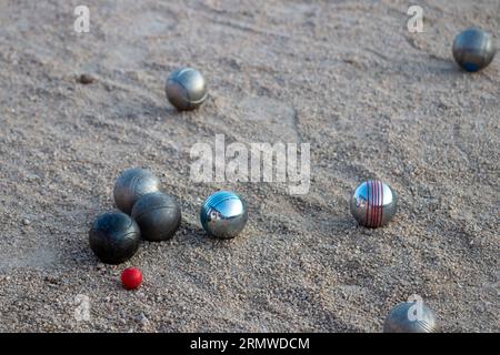 Petanque-Spiel. Sie können die Stahlkugeln in verschiedenen Farben und den Magneten sehen, mit dem sie gesammelt werden. Stockfoto