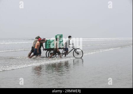 (141026) -- CALCUTTA, 26. Oktober 2014 -- indische Fischer laufen durch das Meerwasser, nachdem sie Fische für eine spätere Auktion auf einem Markt in der Nähe von Digha Sea Beach gesammelt haben, etwa 180 km entfernt von Calcutta, der Hauptstadt des ostindischen Bundesstaates West Bengal, 26. Oktober 2014. Die Fischerei ist in den indischen küstenstaaten mit über 14 Millionen Beschäftigten ein wichtiger Wirtschaftszweig. Tumpa Mondal) (zjy) INDIA-CALCUTTA-FISH MARKET e TumpaxMondal PUBLICATIONxNOTxINxCHN CALCUTTA OCT 26 2014 indische Fischer laufen durch das Meerwasser, nachdem sie Fisch für eine SPÄTERE Auktion AUF einem Markt in der Nähe von Digha Sea Beach, etwa 180 km von Calcutta Capital of EA entfernt, gesammelt haben Stockfoto