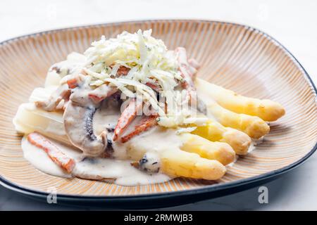Weißer Aparagus mit Pilzsauce und Schinken, serviert mit Blauschimmelkäse Stockfoto