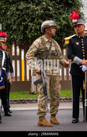 Lima, Peru - Juli 29 2023: Peruanischer Mann in Tarnuniform mit einer Waffe spricht mit einem anderen Mann bei der Militärparade am Unabhängigkeitstag Stockfoto