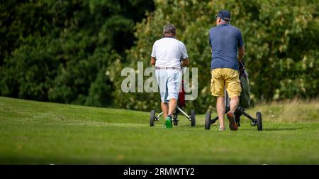 PRODUKTION - 24. August 2023, Niedersachsen, Adendorf: Golfer laufen über einen Golfplatz. Das Image der Golfer und ihrer Vereine ist voller Vorurteile: Zu elitär und nicht sehr umweltfreundlich. Ist die Bewässerung der langen Gänge in Zeiten von Wasserknappheit immer noch gerechtfertigt? (Zu dpa "zu wenig Regen: Golfplätze basteln an Bewässerungskonzepten") Foto: Philipp Schulze/dpa Stockfoto