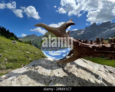 Stillleben von eindrucksvollem rehbockgeweih (Jagdtrophäe), neben Linsenkugel, Kristallkugel, mit Reflexionen des Gauertals (Montafon, Vorarlberg) Stockfoto