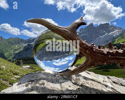 Stillleben von eindrucksvollem rehbockgeweih (Jagdtrophäe), neben Linsenkugel, Kristallkugel, mit Reflexionen des Gauertals (Montafon, Vorarlberg) Stockfoto