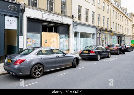 Bewachte Geschäfte in New Bond Street, Bath, Großbritannien, August 2023. In vielen britischen Hochstraßen ist die Zahl der heruntergekommenen Geschäfte gestiegen. Stockfoto