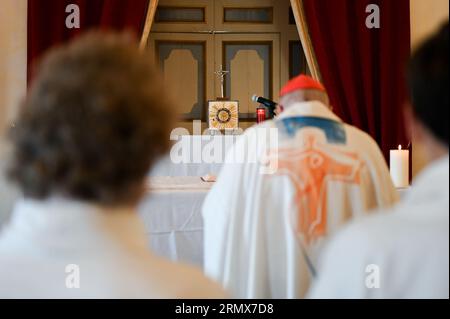 Ein Kardinal betet vor Altar und Tabernakel nach der heiligen Messe in einer Kapelle. Stockfoto