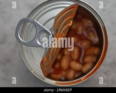 Halb geöffnete Dose mit Ringzug, mit gebackenen Bohnen in Tomatensauce Stockfoto