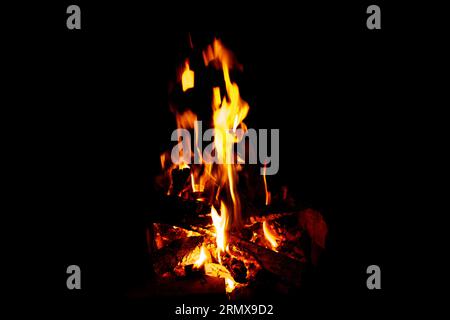 Flammen auf schwarzem Hintergrund. Brennendes Holz in der Nacht, Lagerfeuer Stockfoto