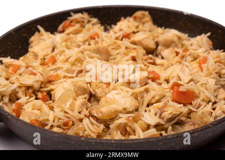 Leckerer Pilaf mit Huhn in der Pfanne. Isoliert auf weißem Hintergrund. Stockfoto