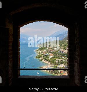 Blick durch ein Fenster auf die Scaliger Burg, Castello Scaligero auf dem nördlichen Gardasee bei Malcesine in Italien Stockfoto