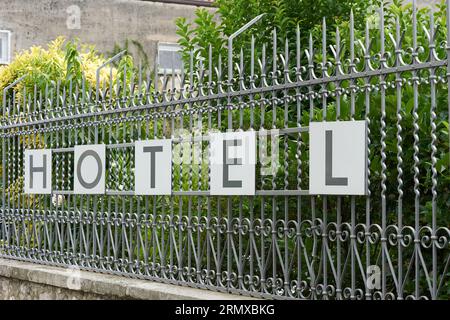 Hotel mit Schriftzug am Zaun eines Hotelkomplexes im beliebten Ferienort Malcesine am Gardasee in Italien Stockfoto