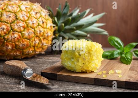 Französischer Ziegenkäse mit Ananasstücken auf einem Holzbrett, Ananas und Basilikum Stockfoto
