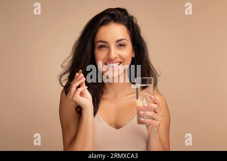 Glückliche, tausendjährige indianerin, die Schönheitspille nimmt Stockfoto