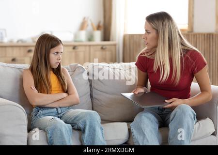 Strenge Mutter beschimpft junge Tochter für lange Laptop-Nutzung Stockfoto