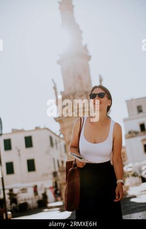 Weibliche Touristen mit einem Stadtplan von der Statue des Heiligen Oronzo in Ostuni, Italien Stockfoto