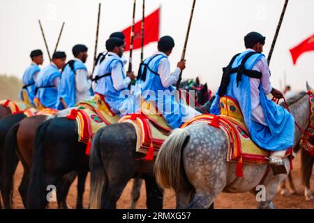 Reiterinnen und Reiter, die an einer traditionellen Kostümveranstaltung mit dem Namen Tbourida teilnehmen, in arabischer Sprache, in einem traditionellen marokkanischen Outfit Stockfoto