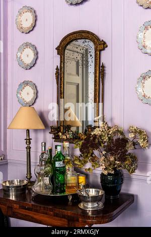 Dekorative Teller und goldgerahmter Spiegel mit Getränketablett in einem aus dem 18. Jahrhundert stammenden Blumenloft in der Nähe von Penzance in Cornwall, Großbritannien Stockfoto