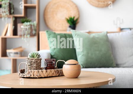 Couchtisch mit Zimmerpflanze und modernem Luftbefeuchter im Wohnzimmer Stockfoto