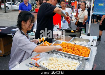 Ein Arbeiter von Sol bereitet Hühnchen- und Reiskuchen-Spieße bei einem Think zu! Chinatown Night Market Event in Chinatown, New York, 23. Juli 2023. Stockfoto