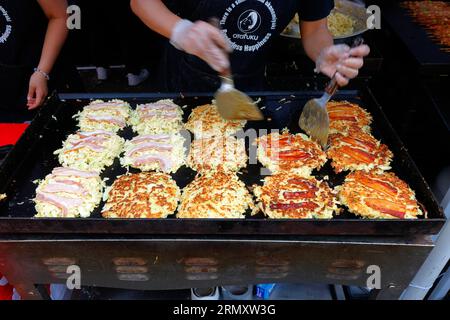 Ein in Osaka-Ya ansässiger Grilltechniker bereitet Okonomiyaki im Osaka-Stil auf der Straßenmesse des Japan Fes Food Festivals an der 4th Ave, New York City, 27. August 2023, zu. Stockfoto