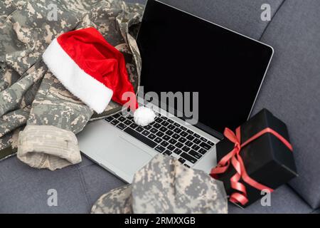 Militäruniform und Weihnachtsmannmütze mit Laptop. Das Konzept von Weihnachten und Neujahr. Stockfoto