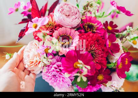 Blick von oben auf den Blumenstrauß aus rosa Dahlia Zinnia Blumen. Inneneinrichtung und Einrichtung im Sommer zu Hause. Frau genießt frische Blüten. Nahaufnahme des Blumenarrangements Stockfoto
