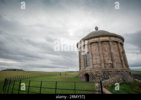 Mussenden-Tempel im Norden irlands bei Demesne bergab an einem bewölkten Tag, der sich zwischen dem Gras versteckt. Wunderschönes Mausoleum in der irischen Landschaft. Stockfoto