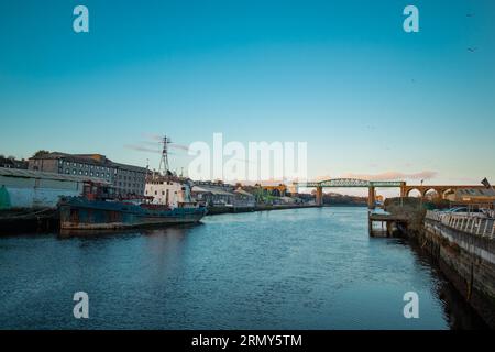 Fantastisches Boyne-Viadukt in drogheda, das sich am frühen Abend über den Fluss Boyne erstreckt. Wunderschöne Puktur eines grünen Metallviadukts und Steinbögen. Stockfoto