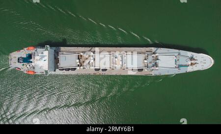 Frachtschiff, das von oben sichtbar ist und durch die Gewässer der Panamakanalstraße fährt. Graues Schiff, Drohnenansicht von oben. Stockfoto