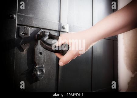 Nahaufnahme der Hand einer Frau, die den Griff einer Tür hält. Weicher Filter auf dem Bild Stockfoto