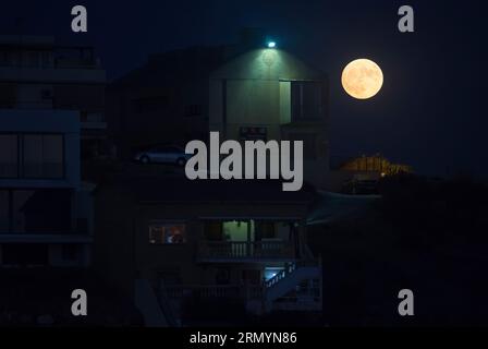 Malaga, Spanien. 30. August 2023. Der blaue Supermond, der zweite Supermond im August, erhebt sich am Himmel neben Gebäuden am Strand „La Araña“. Der blaue Supermond ist eines der auffälligsten astronomischen Ereignisse des Monats. Wenn der Vollmond stattfindet, erscheint er größer und heller als normal. (Foto: Jesus Merida/SOPA Images/SIPA USA) Credit: SIPA USA/Alamy Live News Stockfoto