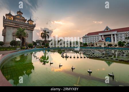 Im Patuxay Park, neben dem berühmten Wahrzeichen der Hauptstadt und dem Kriegsmahnmal, beleuchtet, wunderschönes Nachglühen des Sonnenlichts, in der Abenddämmerung, beliebte Touristenattraktion, pe Stockfoto