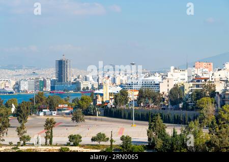 Blick auf Athen, den Parthenon-Tempel und das Propyläen-Tor auf dem Akropolis-Hügel, mit dem Berg Lycabettus hinter, vom Hafen Piräus Griechenland. Stockfoto