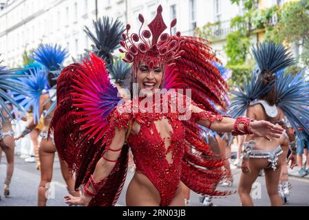 London, Großbritannien. 28. August 2023. Eine wunderschöne Samba-Tänzerin in einem farbenfrohen Kostüm posiert für ein Foto während der Parade des Notting Hill Karnevals in London. Der Notting Hill Carnival ist eines der größten Straßenfeste der Welt. Es begann 1966, entstand aber aus dem Karibischen Karneval, der 1959 mit der Immigrantengemeinschaft aus Trinidad und Tobago organisiert wurde. In diesem Jahr feiert der Notting Hill Carnival den 50. Jahrestag der Einführung der Soundsysteme und Mas-Bands. Es ist auch der 75. Jahrestag der Ankunft der Passagiere der Empire Windrush nach t Stockfoto