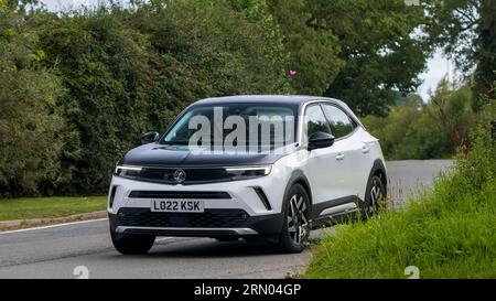 Whittlebury, Northants, UK - 27. August 2023: 2022 weißes Elektroauto vauxhall Mokka Elite, das auf einer englischen Landstraße fährt Stockfoto