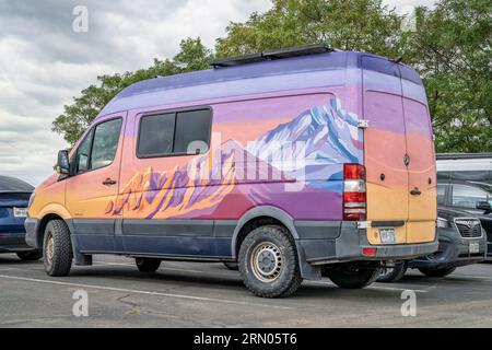 Loveland, CO, USA - 25. August 2023: Mercedes Sprinter Wohnmobil mit farbenfroher Bergmotiv-Grafik. Stockfoto