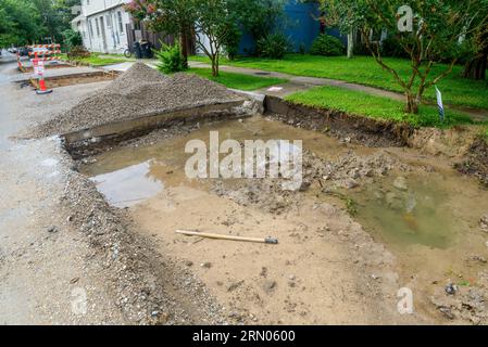 NEW ORLEANS, LA, USA - 6. JUNI 2021: Unvollendetes Straßenreparaturprojekt mit stehendem Regenwasser und Schlamm im ausgegrabenen Teil der Straße Stockfoto
