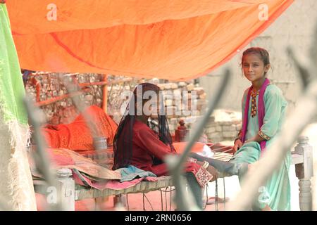 Khumbri, Pakistan. Juli 2023. Zwei Mädchen sitzen unter einem Dach aus Stoff in einem Dorf in der Provinz Sindh. Nach den Überschwemmungen mussten viele Familien ihre Häuser mit einfachsten Mitteln wieder aufbauen. Als Pakistan zwischen Juni und Oktober 2022 die verheerendsten Überschwemmungen in seiner Geschichte erlebte, fegte das Wasser Vieh, Häuser und Schulen weg.(to dpa 'with the flood our lives stop' - People in Pakistan in fear') Credit: Aijaz Korai/dpa/Alamy Live News Stockfoto