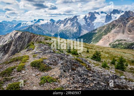 Ein felsiger Bergrücken im Bugaboo Provincial Park, BC, mit Blick auf den Bugaboo Spire, Gletscher und andere nahe gelegene Gipfel Stockfoto