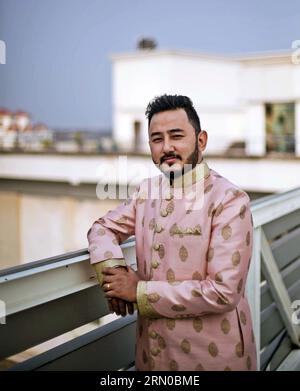 Der nepalesische Bräutigam, der am glücklichen Tag seiner Hochzeit in einem zarten rosa Sherwani-Mantel gehalten war, strahlte Eleganz und Vorfreude aus. Stockfoto