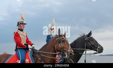 30. August 2023, Fredericia, Dänemark, ein roter und ein blauer Husar in Uniform reiten zu einer Pferdeshow in Fredericia Stockfoto