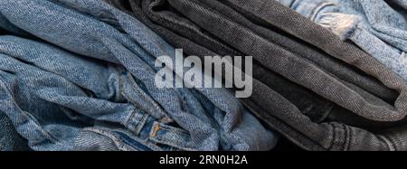 Abstrakter Jeanenstapel. Hintergrund Mode Jeans strukturiert verschiedene Farbtöne Denim. Leinwand Denim Textur. Blaues Denim Closeup Stockfoto