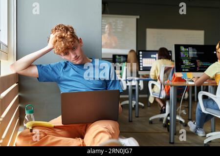 Schüler, der ein Notebook im Klassenzimmer benutzt, während er es lernt Stockfoto