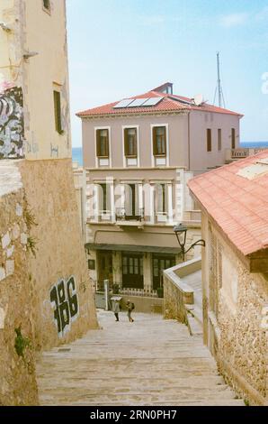 Ein Blick auf eine kleine griechische Stadtstraße in Chania, Kreta von oben auf einer Steintreppe, alte Steinmauern rundherum Stockfoto