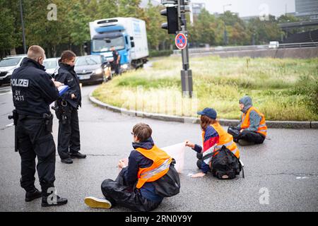 München, Deutschland. 29. August 2023. Am 29. August blockierten 2023 Aktivisten der letzten Generation mehrere Straßen in München. Die LastGen sieht die bayerischen Politiker als schlimmste Klimapolitik-Blockierer. Ferner fordert die letzte Generation eine Geschwindigkeitsbegrenzung von 100 km/h auf Autobahnen, die Einführung eines neun-Euro-Tickets und einen Rat der Klimagesellschaft. (Foto: Alexander Pohl/SIPA USA) Credit: SIPA USA/Alamy Live News Stockfoto