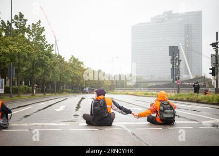 München, Deutschland. 29. August 2023. Am 29. August blockierten 2023 Aktivisten der letzten Generation mehrere Straßen in München. Die LastGen sieht die bayerischen Politiker als schlimmste Klimapolitik-Blockierer. Ferner fordert die letzte Generation eine Geschwindigkeitsbegrenzung von 100 km/h auf Autobahnen, die Einführung eines neun-Euro-Tickets und einen Rat der Klimagesellschaft. (Foto: Alexander Pohl/SIPA USA) Credit: SIPA USA/Alamy Live News Stockfoto